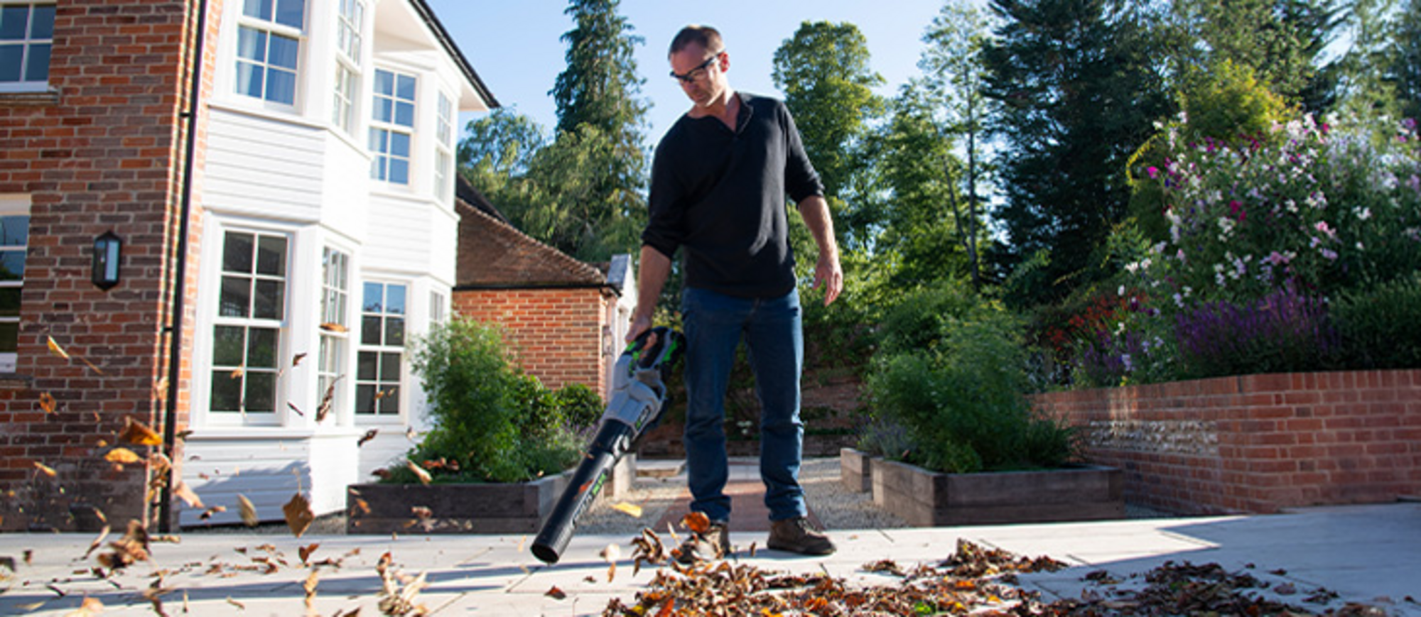 Ein Mann entfernt Laub mit einem EGO Power+ Akku-Laubbläser.